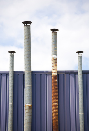 Four ventilation pipes over blue sky closeupの写真素材