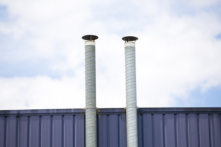 Two ventilation pipes over blue sky closeupの写真素材