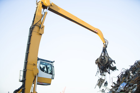 Crane grabber loading metal rusty scrap in the dockの写真素材
