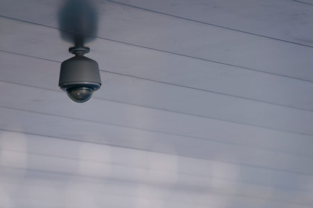 Camera system guarding blue skyscraper office building with blue sky above in horizontal format