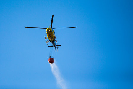 GRANADA, AUGUST 28: Fire fighting Helicopter, with bambi basket, during a fire fighting in the bush....
