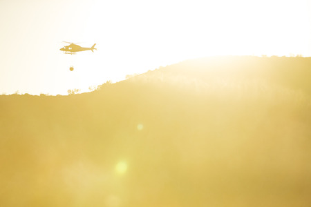 GRANADA, AUGUST 28: Fire fighting Helicopter, with bambi basket, during a fire fighting in the bush. August 28, 2014, Granada, Spain.のeditorial素材