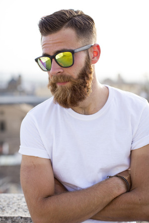 Bearded man posing in the street with sunglasses.の写真素材
