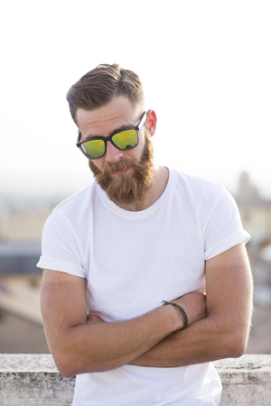 Bearded man posing in the street with sunglasses.の写真素材