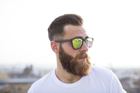 Bearded man posing in the street with sunglasses.の写真素材