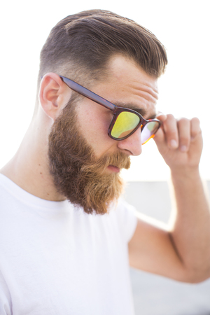 Bearded man posing in the street with sunglasses.の写真素材