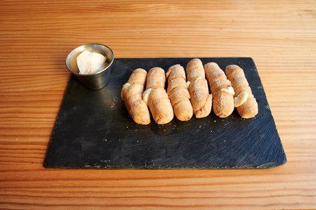 A plate with a container of butter on the table. The items are arranged in a row and are covered in...