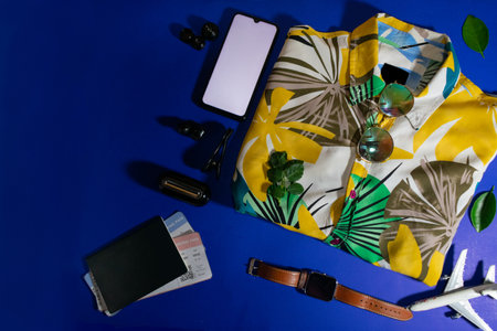 top view travel concept with passport, smartphone, on blue background with copy space, Tourist essentials, airplaneの写真素材