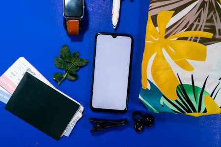 Top view mobile phone with application, passport and shirt close-up. Trip, journey, travel, emigration, vacation concept.の写真素材