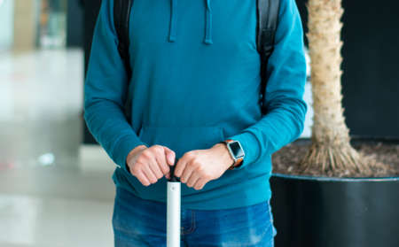 an anonymous person holds his suitcase at the airportの写真素材