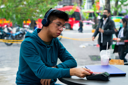 a young man makes contactless payment with a card with copy spaceの写真素材