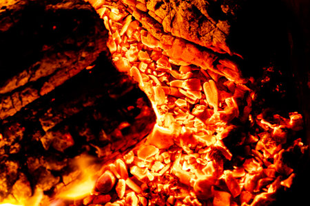 Incandescent details of orange and red charcoal embers for barbecue at the picnic. Texture