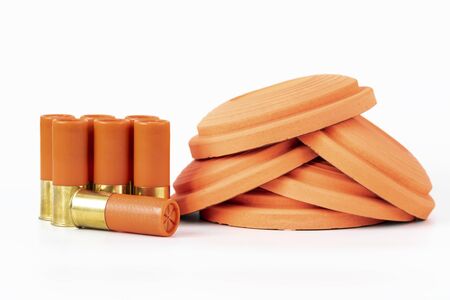 Clay pigeons and shotgun cartridges on a white background.の写真素材