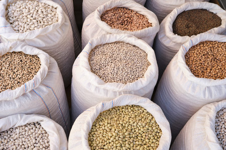 From above of a variety of legumes in open sacks placed in rows at the local bazaar