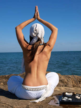 Woman doing yoga by the seaの写真素材