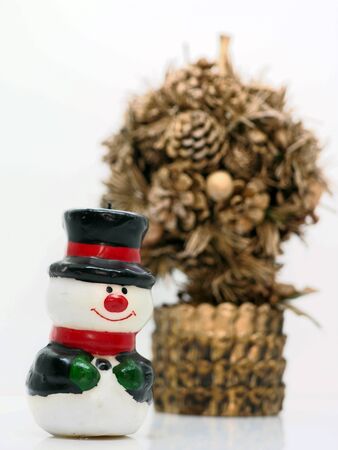 Small snowman by a golden christmas treeの写真素材