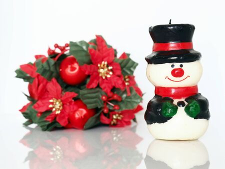 Small snowman and red christmas flowersの写真素材