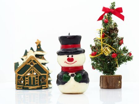 Snowman and small christmas tree against white backgroundの写真素材