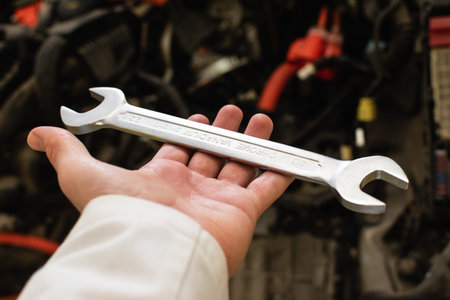 Open hand of a caucasian man holding a wrench, prepared to fix a car