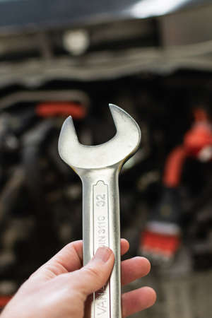 hand of a caucasian man holding a wrench with decision, prepared to fix a carの写真素材