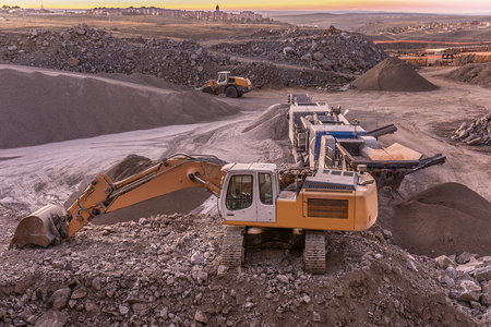 Excavator moving stone in an open pit mine in Spain, mainly graniteの写真素材