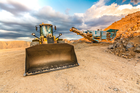 Excavator and stone crusher in a quarryの写真素材