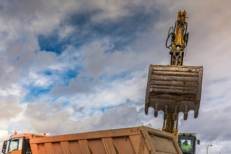 Excavator filling a truck with earth for the construction of a slope in Spainの写真素材