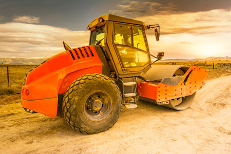 Compactor doing earth compaction work for later asphalting in a road construction