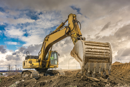 Excavator filling a truck with earth for the construction of a slope in Spainの写真素材