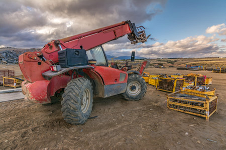 Forklift on a construction site, preparing to raise construction parts