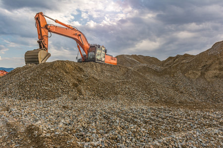 Large excavator on a gravel mountain, making material movements
