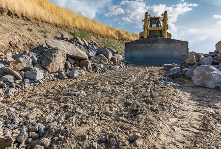 Excavator making a ditch in the construction of a roadの写真素材