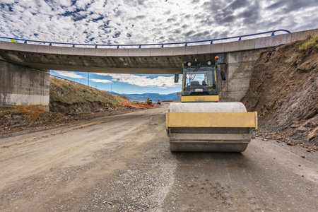 Steamroller performing leveling work on a road under construction