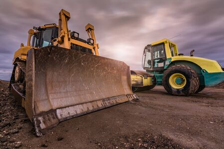 Construction of a dirt road in Spain using an excavator and a steamroller, heavy machineryの写真素材