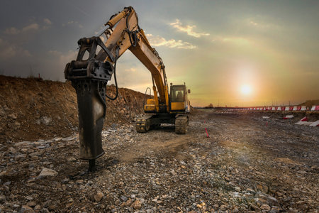 Excavator with hydraulic hammer on road construction works