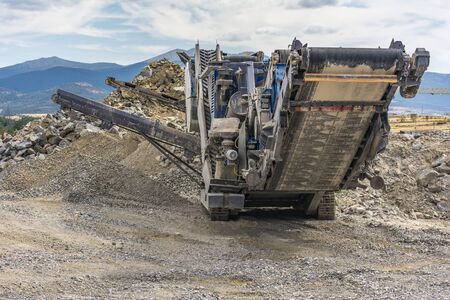 Heavy and mobile machinery in a quarry to transform stone into construction materialの写真素材