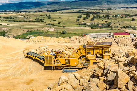 Heavy and mobile machinery in a quarry to transform stone into construction material