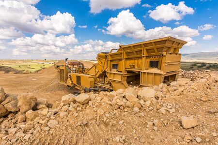 Heavy and mobile machinery in a quarry to transform stone into construction materialの写真素材
