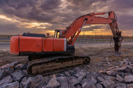 Excavator with hydraulic hammer on road construction works