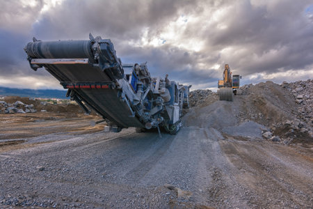 Heavy and mobile machinery in a quarry to transform stone into construction material