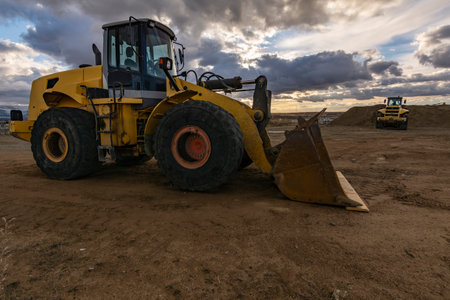 Excavator at the end of a working day at a construction site in a beautiful eveningの写真素材