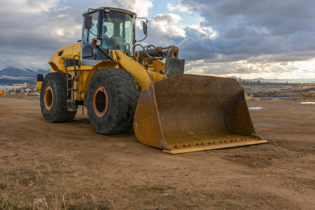 Excavator at the end of a working day at a construction site in a beautiful eveningの写真素材