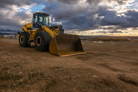 Excavator at the end of a working day at a construction site in a beautiful eveningの写真素材