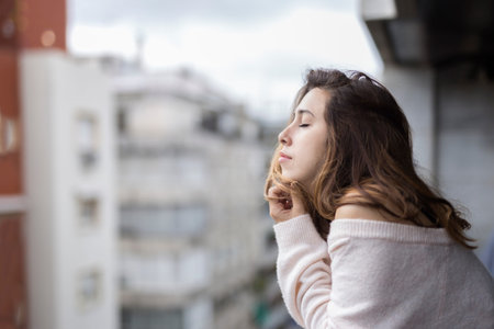 Woman looking from her balcony the city