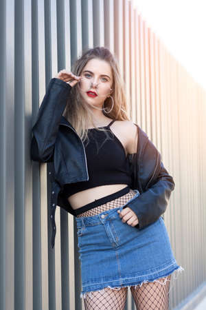 Blonde girl with glasses in trendy posed at sunsetの写真素材