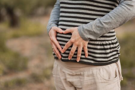 Pregnant woman in nature showing her bellyの写真素材