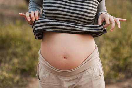 Pregnant woman in nature showing her belly