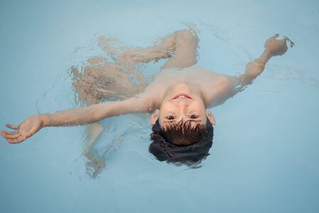 Boy playing in a swimming poolの写真素材