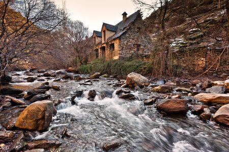 landscape of long exposure river with old rock house in Guejar Sierra, Granada, Spainの写真素材