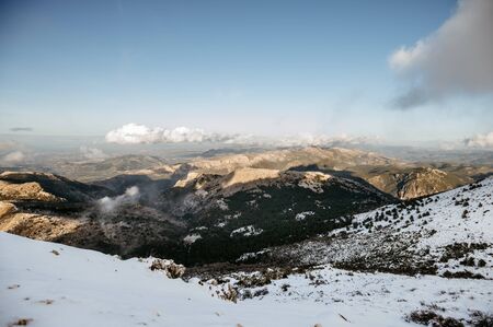 impressive background of a snowy mountain at sunset with dense clouds with lots of colorの写真素材